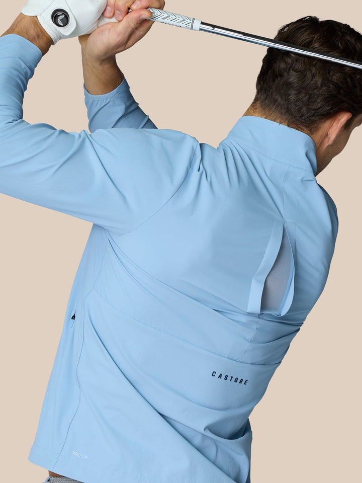 Sky blue Golf Flex Jacket with ProTek water resistance half zip front high funnel neck Castore branding.