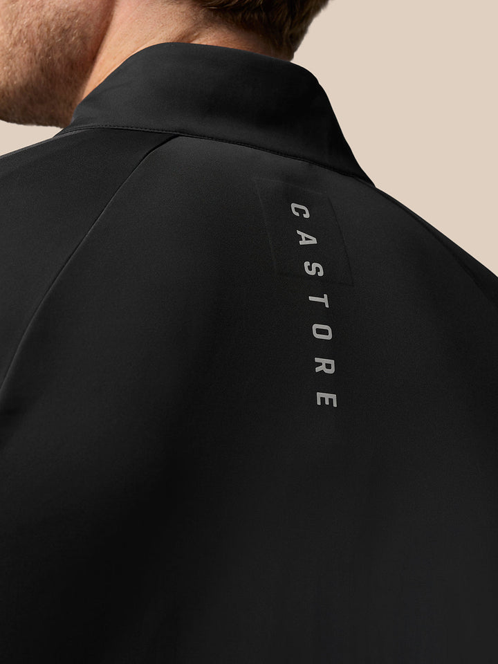 Back view of black Golf Pinnacle Jacket with vertical Castore logo along the upper back.