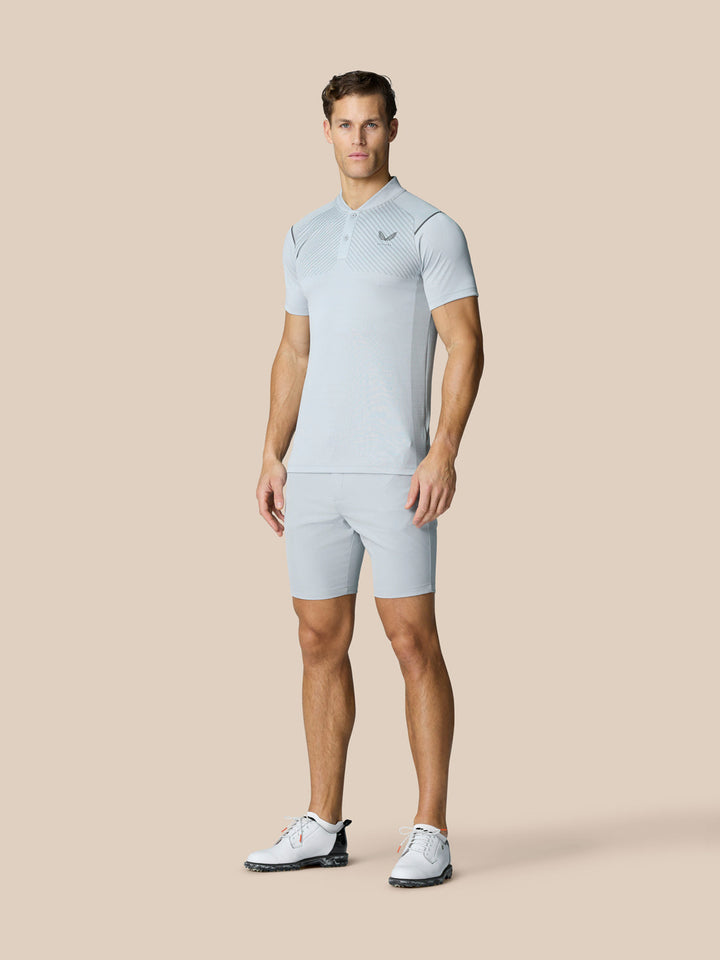 Male model wearing Pinnacle Golf LVS Polo in mid grey with vented knit panels and side splits
