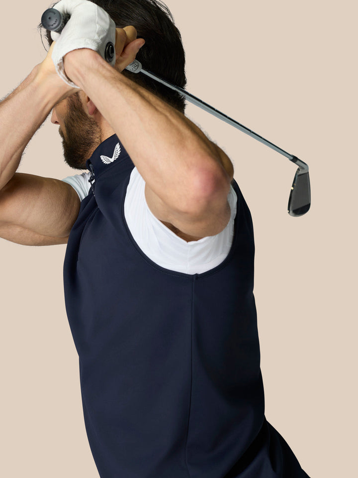 Golfer wearing navy Club 1/2 Zip Gilet with high neck and sleeveless design during a swing