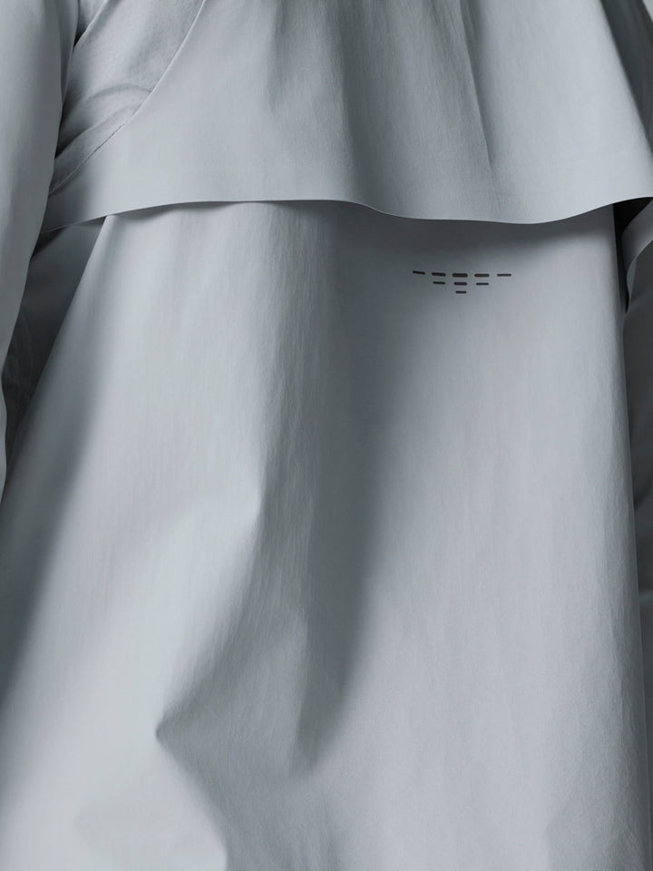 Close-up of light grey Golf Pinnacle LVS Woven Jacket fabric showing back vent detail.