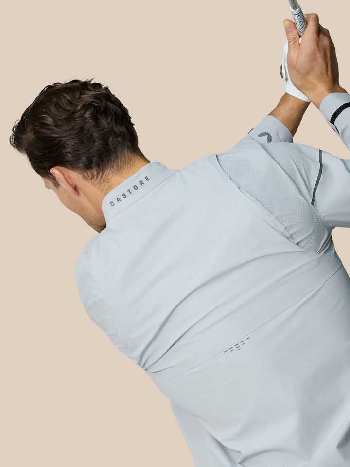 Model wearing Golf Pinnacle LVS Woven Jacket in mid grey with venting mesh panels