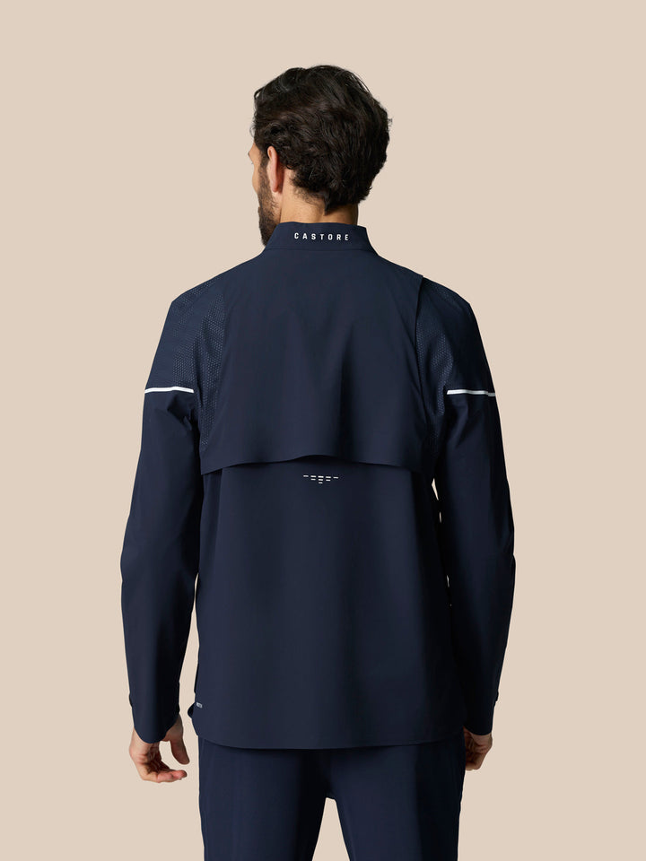 Back view of navy Golf Pinnacle LVS Woven Jacket with mesh shoulder panels white sleeve piping and Castore branding at the neck.