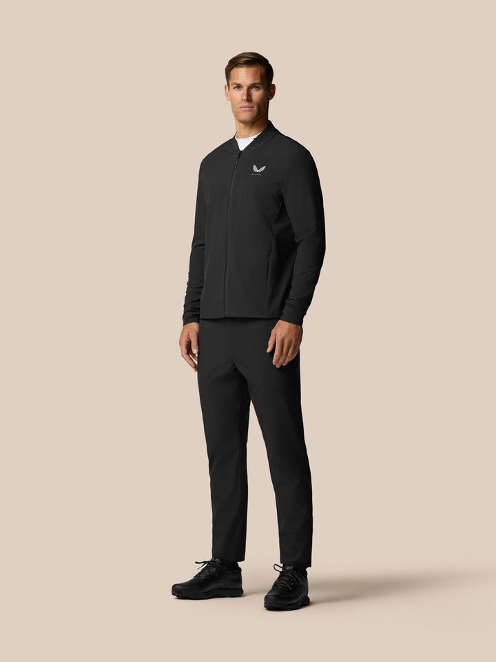 Full body front view of a man wearing a black golf jacket with matching Golf Pinnacle Winter Trousers.