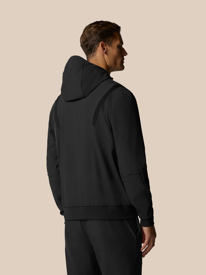 Back view of a man in a black Golf Pinnacle Performance Hoodie showing hood and panel detailing.