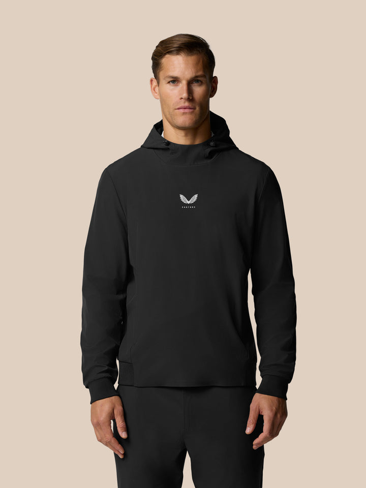 Front view of a man in a black Pinnacle Performance Hoodie with a centered Castore logo on the chest.