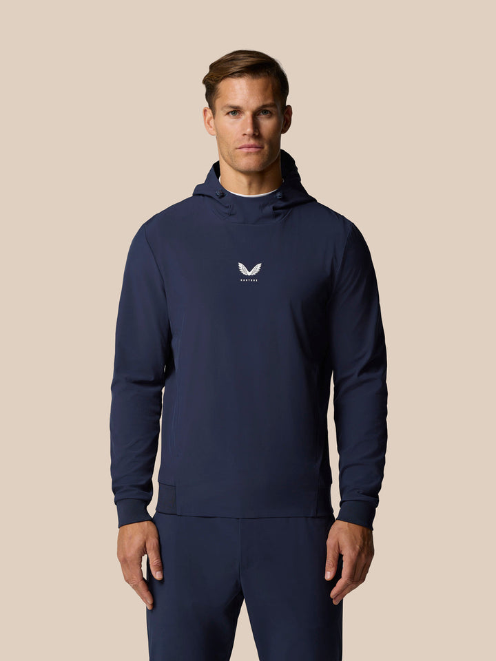 Male model in midnight navy Pinnacle Performance Hoodie with hood and chest logo