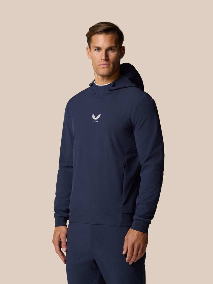Male model wearing navy Golf Pinnacle Performance Hoodie with Castore logo at the center chest.