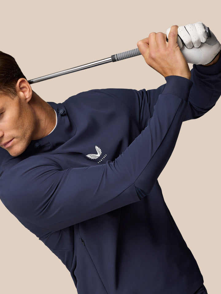 Close up of model in navy Golf Pinnacle Performance Hoodie with Castore logo centered on the chest.
