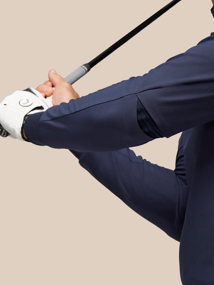 Close up of the navy Golf Pinnacle Performance Hoodie sleeve with elastic panel during a backswing.