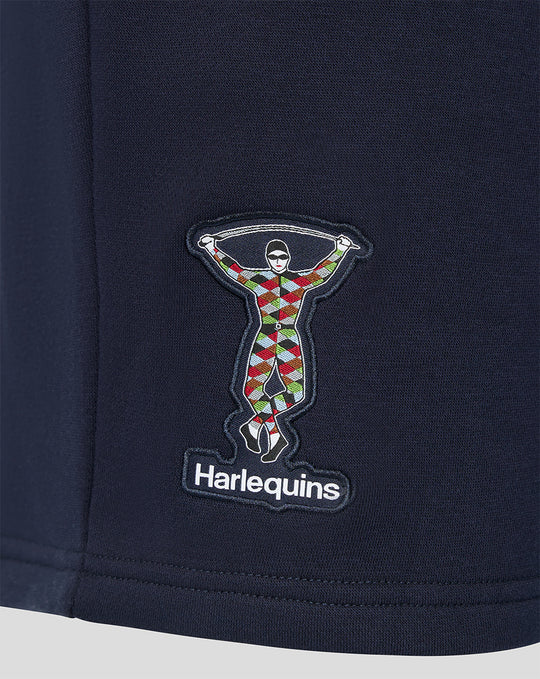 Close-up of the embroidered Harlequins patch showing a colorful harlequin figure on navy fabric.