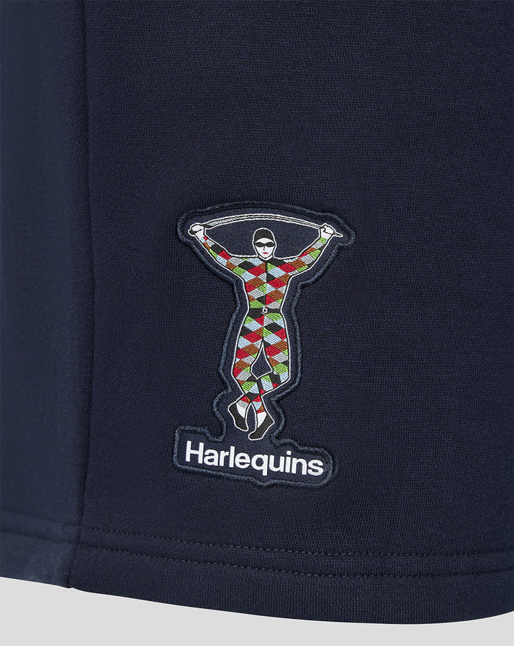 Close-up of the embroidered Harlequins patch showing a colorful harlequin figure on navy fabric.