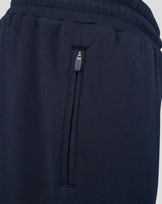 Close up of navy joggers side with a zip pocket and Castore branded zipper pull.