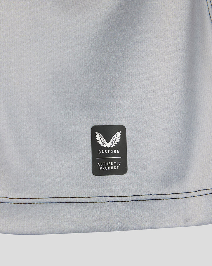 Close-up of light grey jersey fabric with Castore authentic product badge.