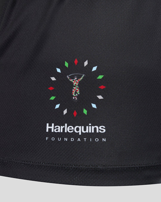 Close-up of Harlequins Foundation emblem on black jersey with a colorful circular motif near the hem
