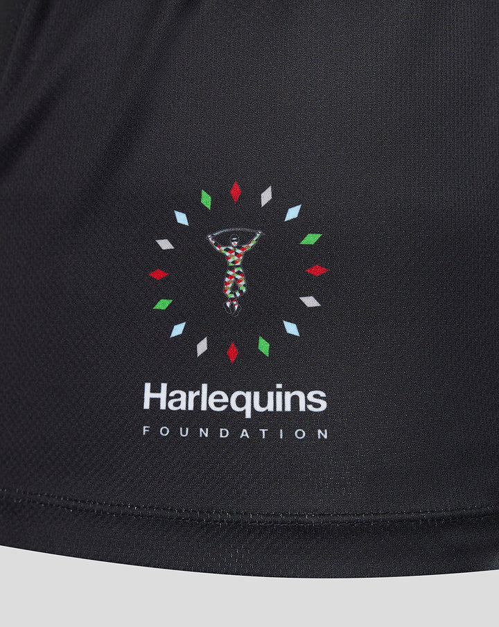 Close-up of Harlequins Foundation emblem on black jersey with a colorful circular motif near the hem