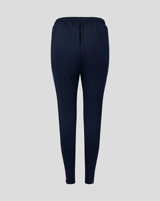 Back view of navy training track pants with elastic waistband and tapered legs.