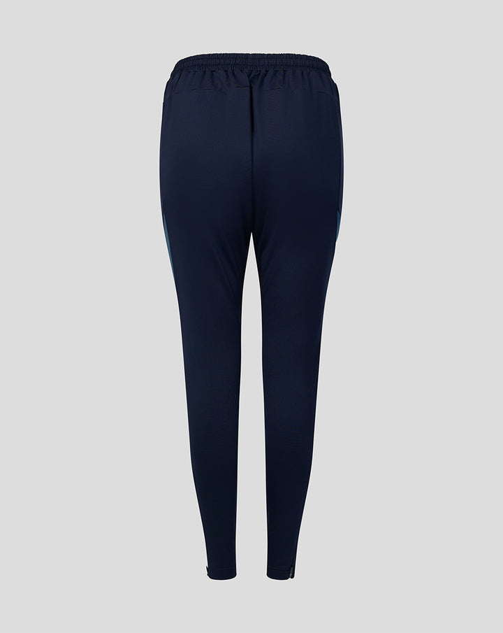 Back view of navy training track pants with elastic waistband and tapered legs.