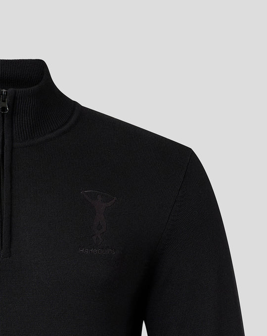 Close-up of black Harlequins quarter-zip top showing tonal embroidered crest and Castore branding on chest