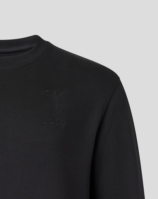 Close up of black Harlequins crew neck sweatshirt with tonal crest embroidery and Castore branding on the chest.