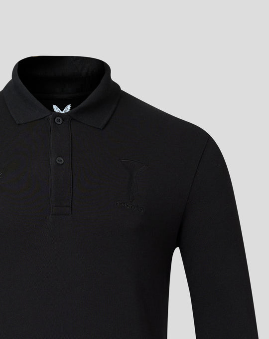 Close up of black Harlequins polo focusing on the embroidered crest and Castore branding on the chest