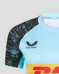Shoulder close-up of light blue jersey showing multicolor sleeve pattern and Castore branding near the neckline.
