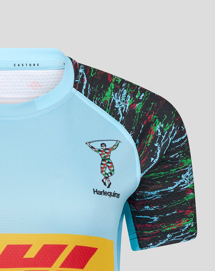 Close-up of chest displaying Harlequins crest on light blue jersey with colorful patterned sleeve.