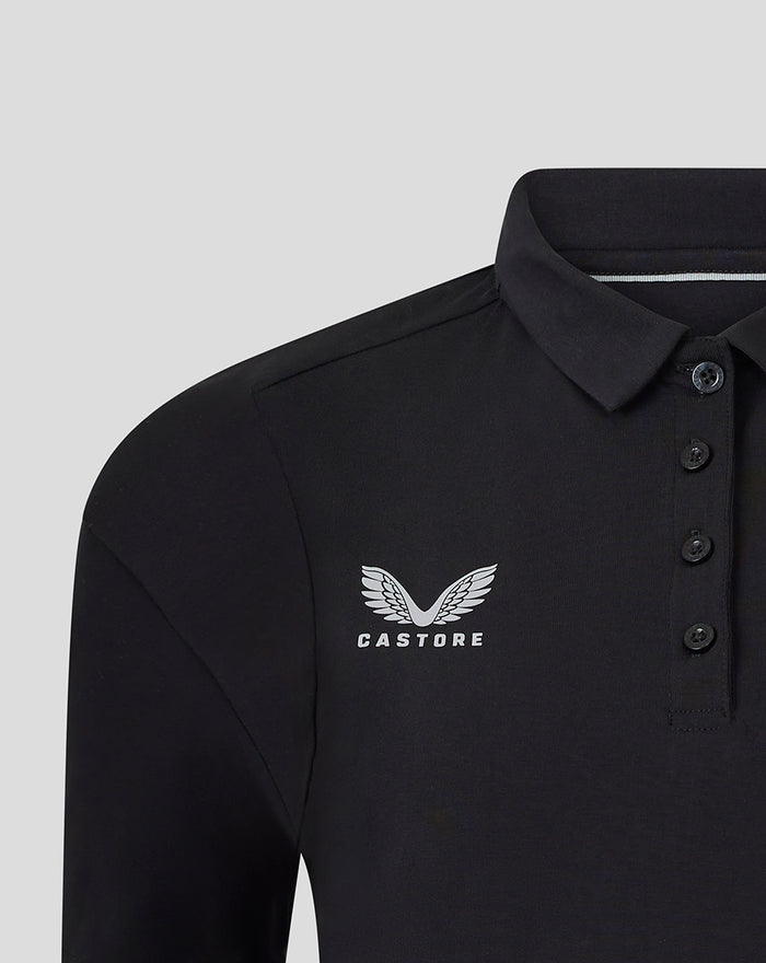 Close-up of a black travel polo showing the winged Castore logo on the chest