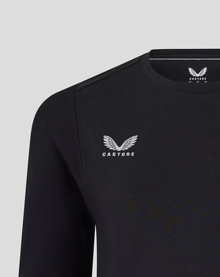 Close-up of black Harlequins travel tee showing Castore logo on the left chest and Harlequins crest on the right.