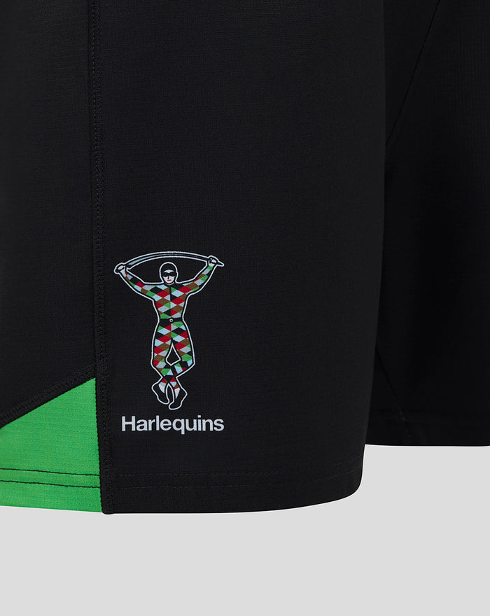 Close-up of black Harlequins home shorts with multicolored club logo and green trim.