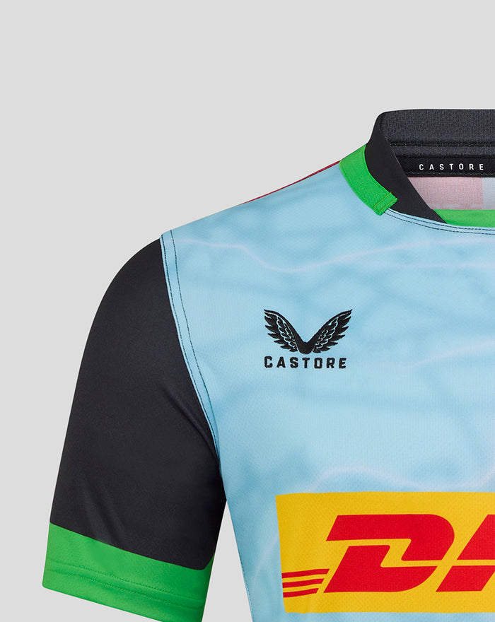 Harlequins home replica shirt close-up shows light blue body black sleeve green cuff with Castore branding and DHL sponsor