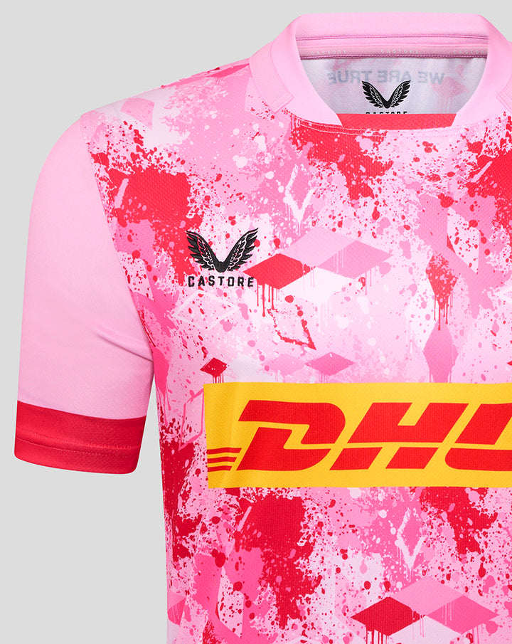 Front view of pink Harlequins away replica rugby shirt with splatter print and DHL logo across the chest