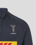 Close-up of navy midlayer chest showing Harlequins crest and Castore logo near a stand collar.