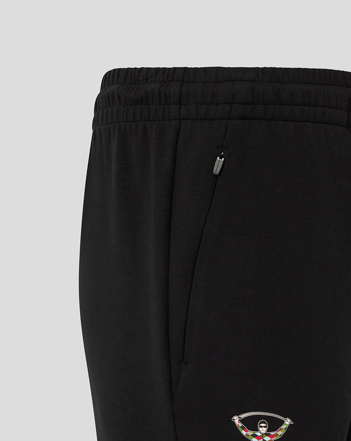 Close up of zip pocket and Harlequins crest at the lower leg of black travel pants