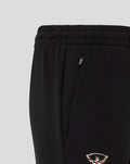 Close up of zip pocket and Harlequins crest at the lower leg of black travel pants