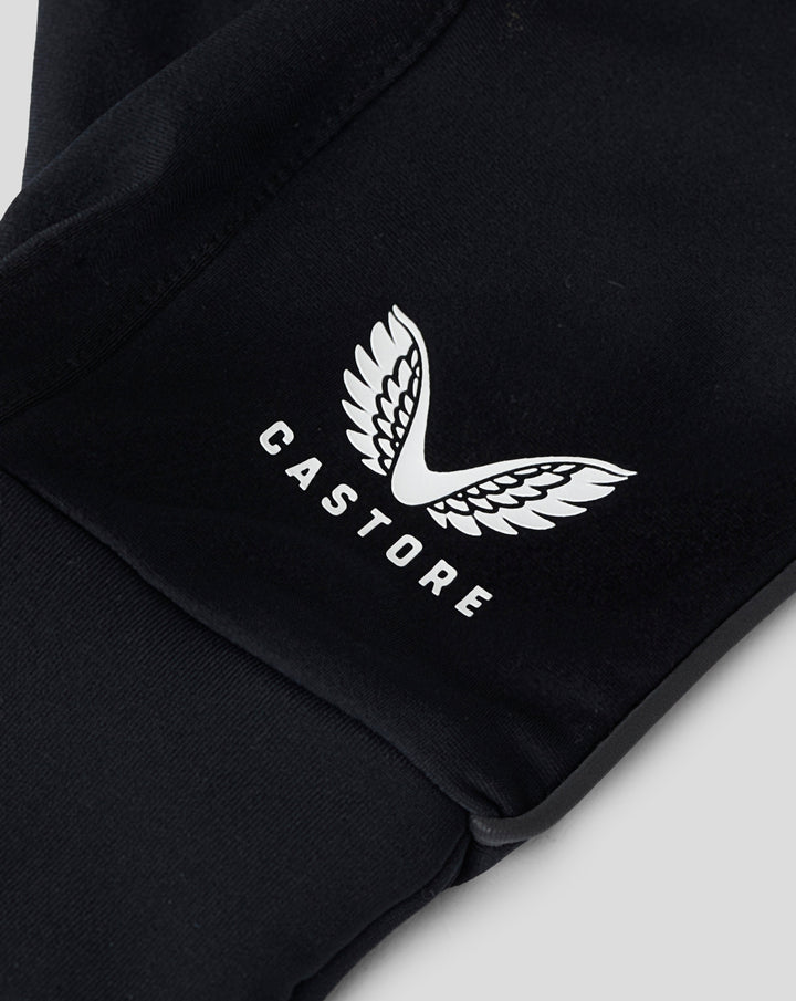 Close-up of black glove fabric featuring a white wing logo on dark material.